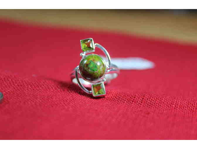 Ring with central round stone flanked by square stones